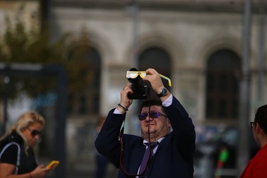 Bucureștenii privesc eclipsa din Piața Universității. | Foto: Dumitru Angelescu / Libertatea