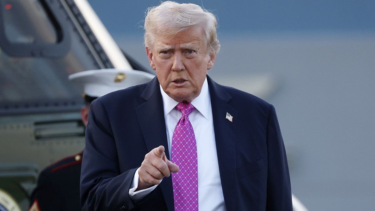 Donald Trump arată cu degetul în timp ce merge după ce a coborât din avion pe aeroportul Morristown, SUA, 14 septembrie 2025