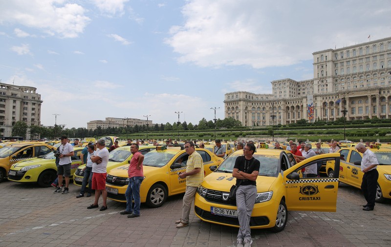 FOTO: Protest al taximetriștilor în București, față de proiectul de lege privind ridesharing. Zeci de mașini blochează Piața Constituției