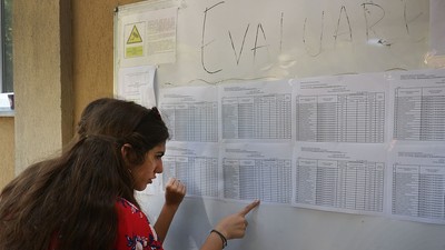 Elevi care îşi caută notele la avizierul şcolii