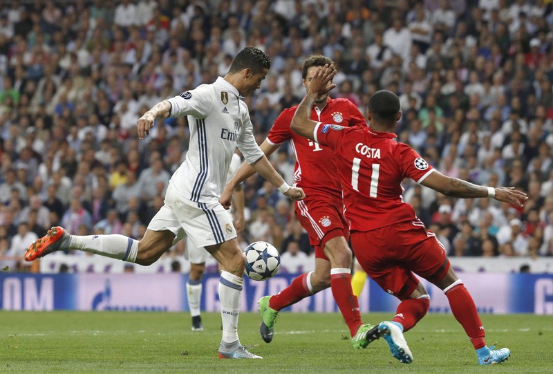 epa05914130 Real Madrid's Portuguese striker Cristiano Ronaldo (L) shoots to score his second goal against Bayern Munich during the UEFA Champions League quarter final, second leg soccer match between Real Madrid and Bayern Munich at Santiago Bernabeu stadium in Madrid, Spain, 18 April 2017. EPA/KIKO HUESCA
