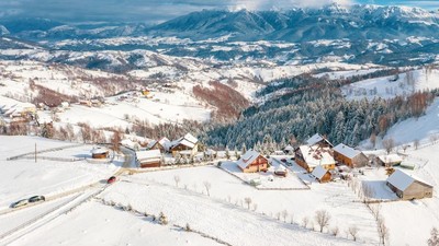 Winter in Romania panoramic view of the Carpathian Mountains and the traditional village Pestera on the Rucar-Bran Pass