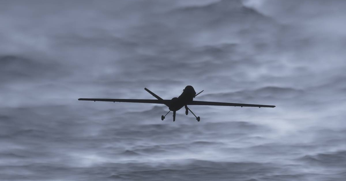 Silueta unei drone de atac, in zbor, pe un cer intunecat, cu nori
