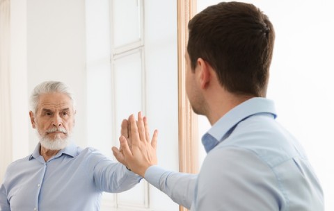 Tânăr văzându-se în oglindă ca senior man. Conceptul de trecut și viitor, flux de timp, vârstă