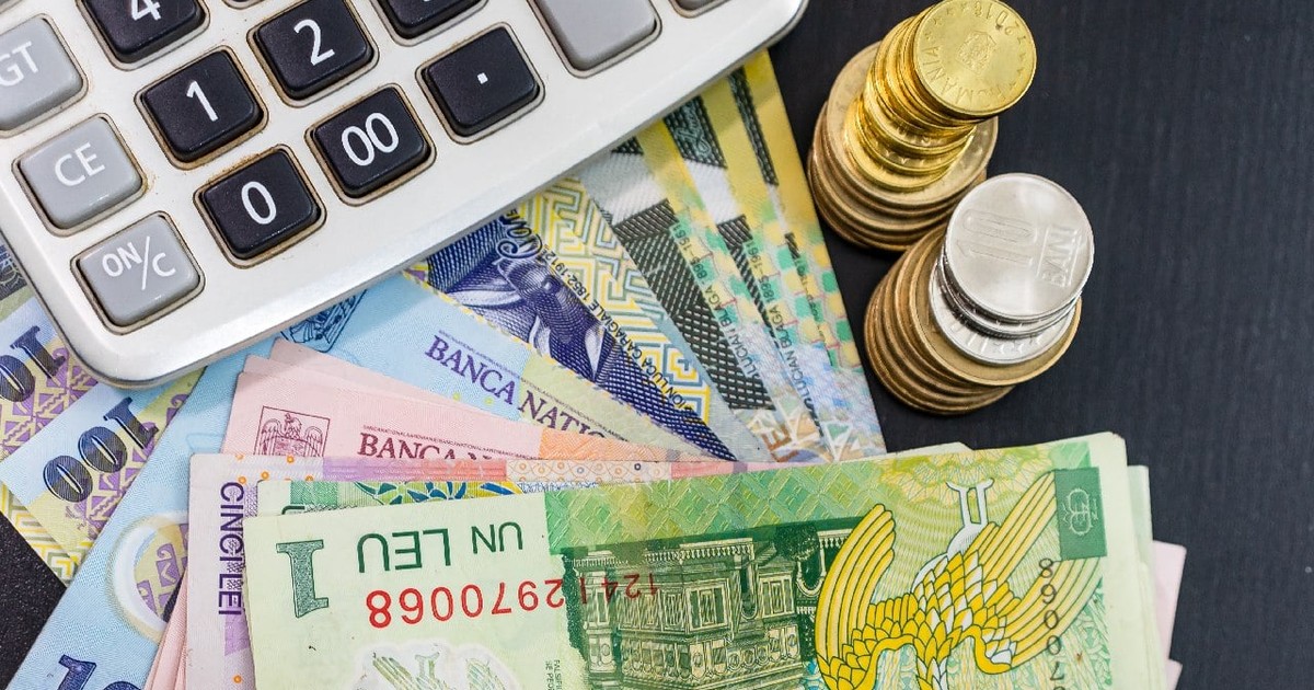 Bancnote și monede langa un calculator