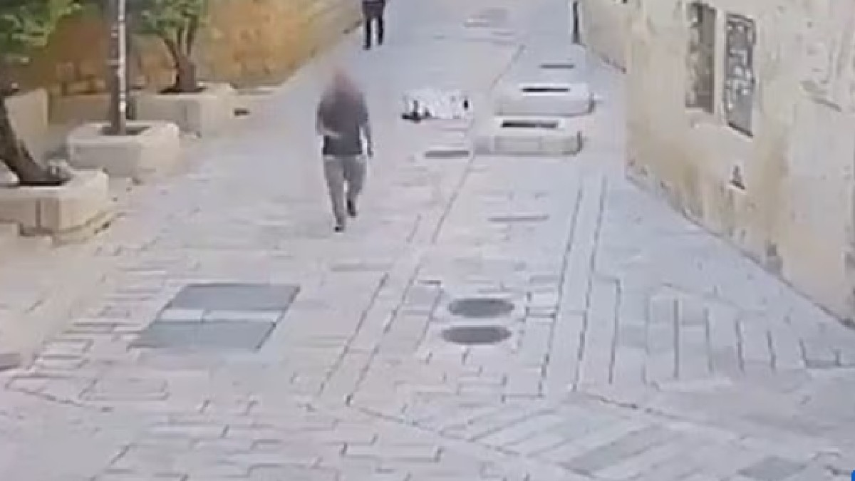O călugăriță care este întinsă pe jos, în timp ce un bărbat cu fața blurată merge pe drum