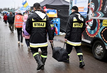 Lucrătorii de urgență ajută refugiații de război din Ucraina când ajung la punctul de trecere a frontierei polono-ucrainene din Medyka, Polonia, 1 aprilie 2022 | Foto: EPA