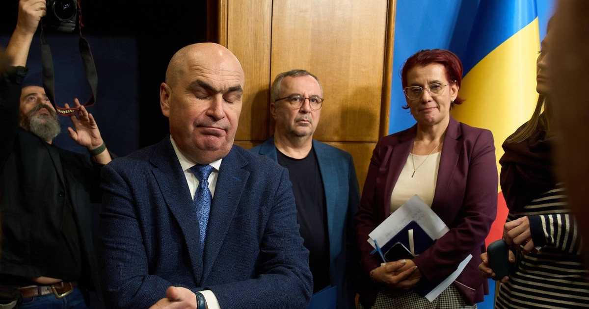 Ilie Bolojan face un gest cu mâna în timp ce pleacă de la o ședință