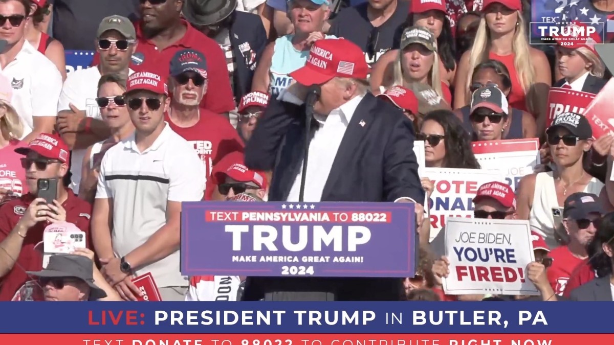 Imaginea îl prezintă pe Donald Trump vorbind la un miting electoral în Butler, Pennsylvania, în fața unei mulțimi de susținători.