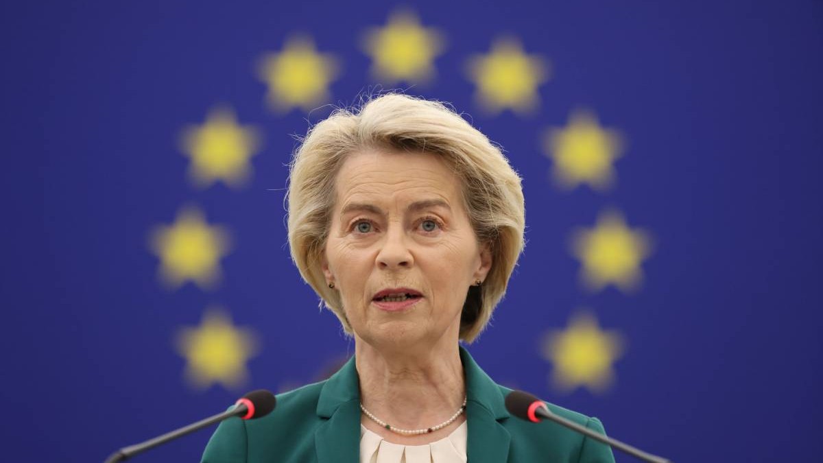 Ursula von der Leyen surprinsă în timp ce vorbește în sesiunea plenară a Parlamentului European, pe 8 iulie 2025. Aceasta poartă un sacou verde, o bluză nude și un colier
