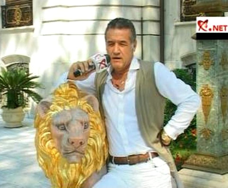 Gigi Becali se sprijină pe-un leu aurit, la el la „palat”