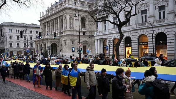 Oamenii poartă un steag ucrainean uriaș în fața Ambasadei Rusiei în cadrul unui marș de solidaritate în sprijinul Ucrainei, organizat la Budapesta, duminică, 22 februarie 2026