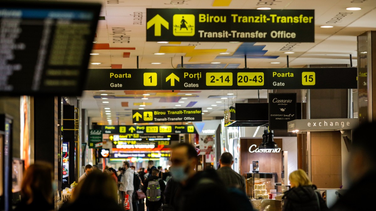 Mai mulți oameni care stau la coadă în Aeroportul Otopeni