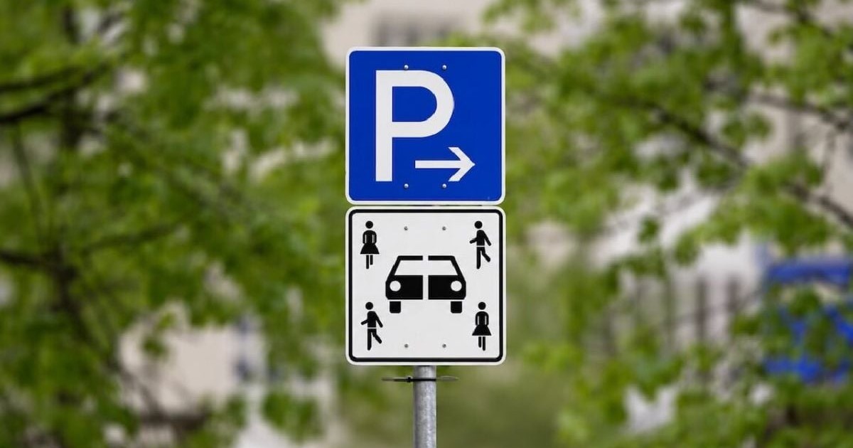 Un indicator de circulație cu litera P, albă pe fond albastru, sub el alt semn cu o mașina rupta în două și patru oameni în jurul ei