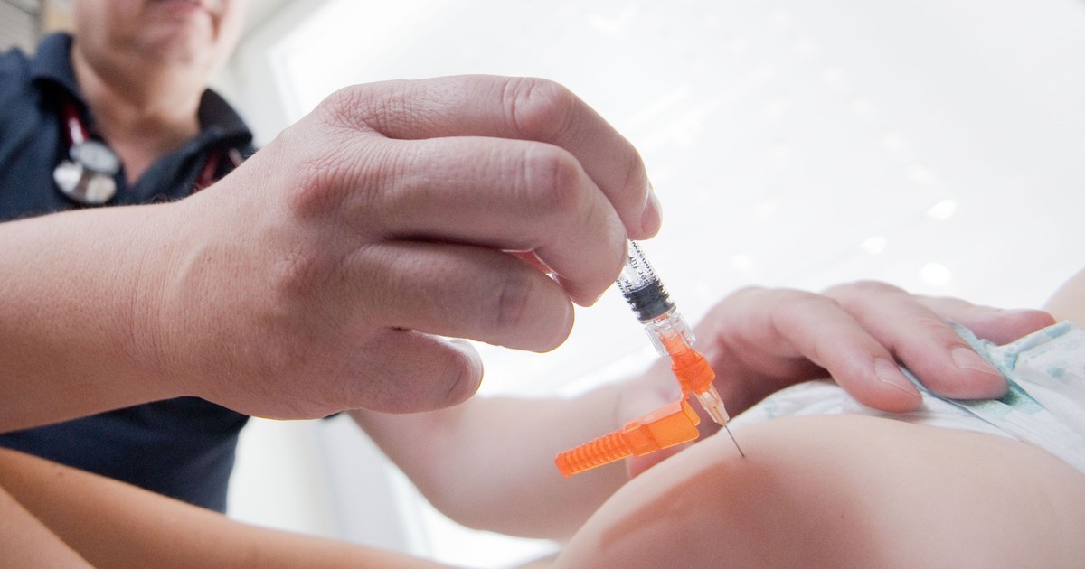 Un doctor vaccinează un copil
