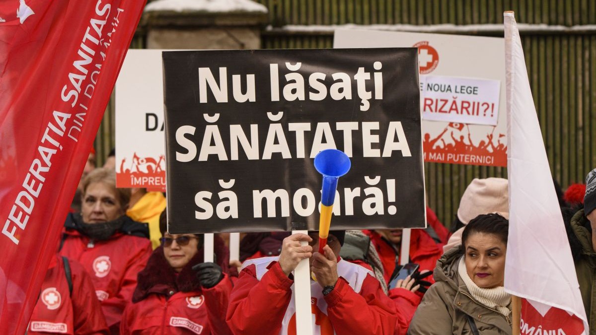 Un barbat afiseaza o pancarta pe care scrie: "Nu lasati sanatatea sa moara!" in timpul unui protest organizat de Federatia Sanitas la ministerul Muncii, in Bucuresti, joi, 25 ianuarie 2024