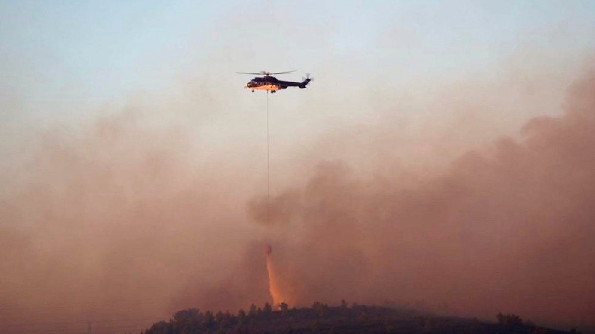Un elicopter al pompierilor aruncă lichid pentru stingerea incendiului de vegetație din Martigues, sudul Franței.