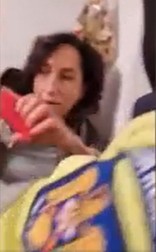 Jurnalista este apucată de mâini de unul dintre polițiști, în încercarea de o scoate din apartament (foto captură România TV)