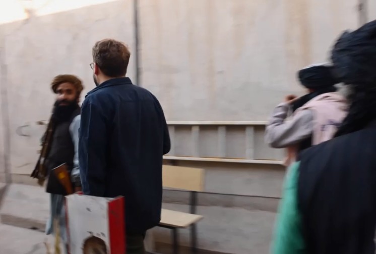 Șeful închisorii primește reporterul german cu arma în mână.