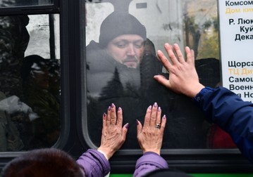O mamă își lipește mâinile de geamul în spatele căruia se află fiul ei, în Chkalovsky, Ekaterinburg, 27 septembrie. Foto: Hepta