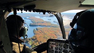 Pilots in the cockpit of the helicopter flying over the Great Lakes