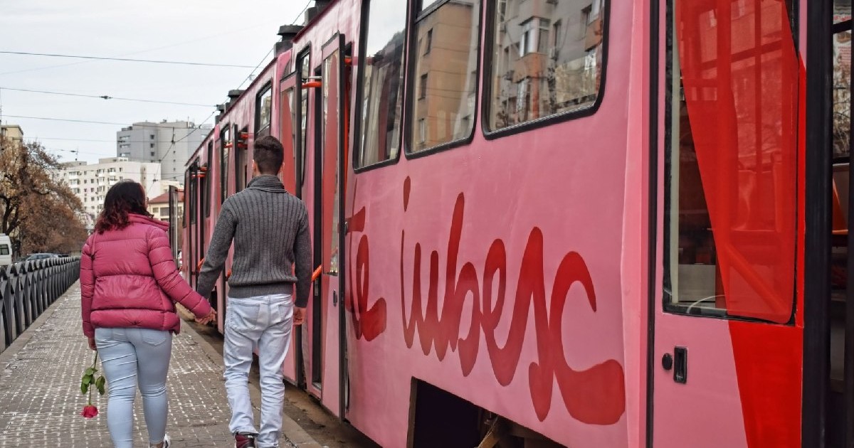 Un cuplu de indragostiti, fata tine un trandafir rosu in mana, lângă un Tramvai roz, Bucuresti