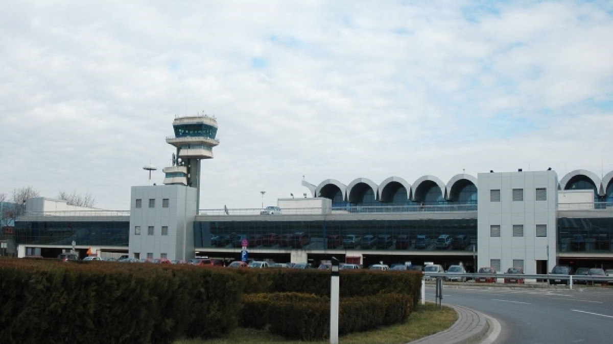 Un turn de control în stânga și clădirea principală a aeroportului Otopeni