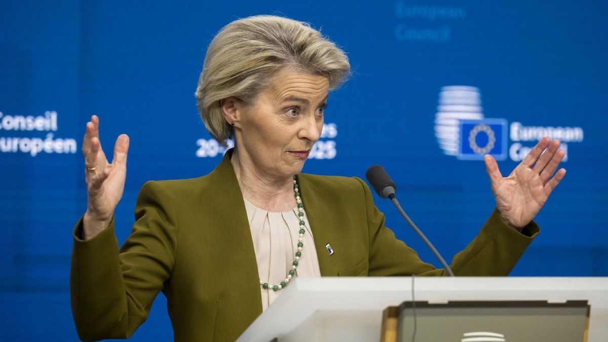 Ursula von der Leyen, cu brațele deschise, purtând un sacou ocru, în timpul unei conferințe de presă după Summit-ul UE privind cheltuielile pentru apărare la sediul Consiliului European din Bruxelles, Belgia.