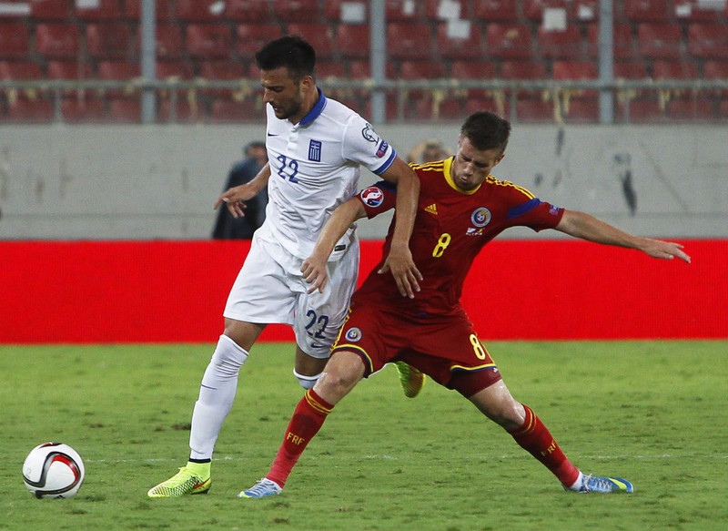 epa04390068 Andreas Samaris (L) of Greece in action against Mihai Pintilii (R) of Romania during the UEFA EURO 2016 qualifying Group F soccer match between Greece and Romania at Karaiskaki stadium in Piraeus near Athens, Greece, 07 September 2014. EPA/YANNIS KOLESIDIS