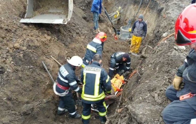 Doi muncitori, prinși sub un mal de pământ. Unul dintre ei a fost decapitat de cupa excavatorului care săpa să-l salveze!