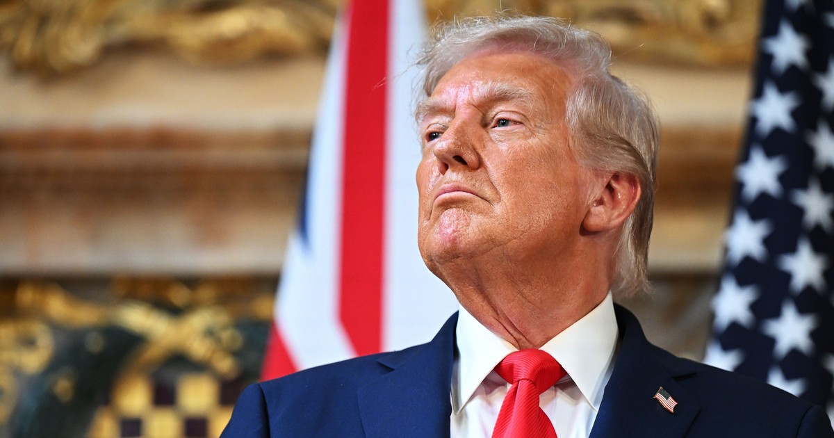 Donald Trump surprins în timpul unei conferințe de presă, în Marea Britanie. Liderul american poartă un sacou albastru închis, o cravată roșie și o cămașă albă