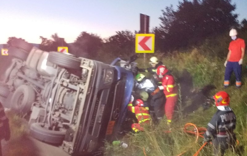 VIDEO|  Un TIR încărcat cu bitum s-a răsturnat în Caraș-Severin. Șoferul, transportat de urgență la spital