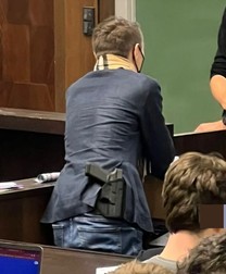 Julian, cu eșarfă Burberry și cu pistolul la vedere, în sala de curs. Captură: Bild