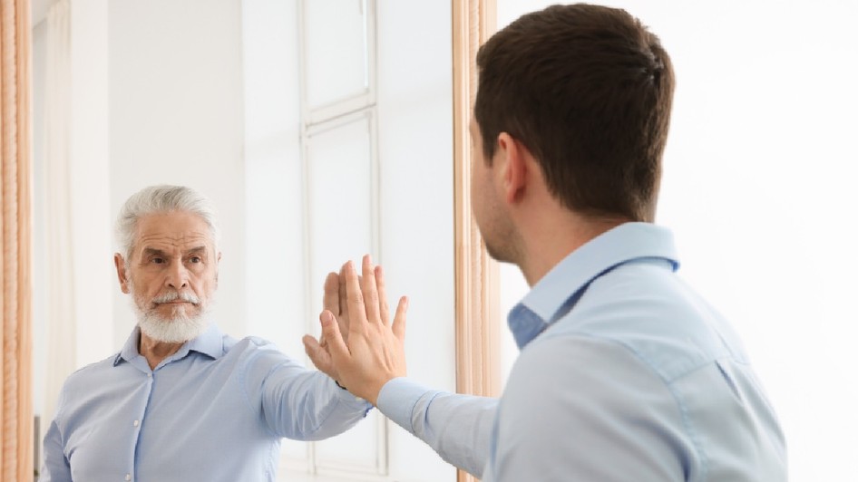 Tânăr văzându-se în oglindă ca senior man. Conceptul de trecut și viitor, flux de timp, vârstă