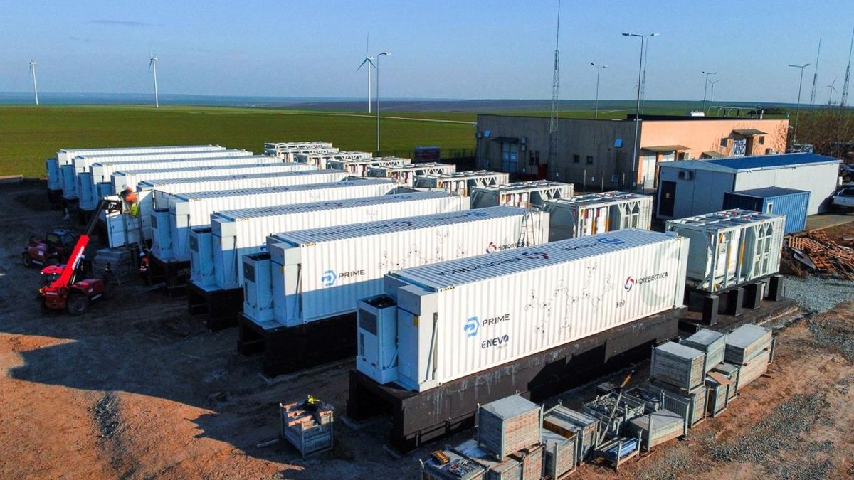 În imagine sunt prezentate toate cele 9 baterii de stocare aferente proiectului BESS din Parcul Eolian Crucea Nord (Sucursala WIND), al Hidroelectrica, cu o capacitate de 36 MW / 72 MWh. Acestea au fost livrate și montate pe poziția finală la data de 30 decembrie 2025.
