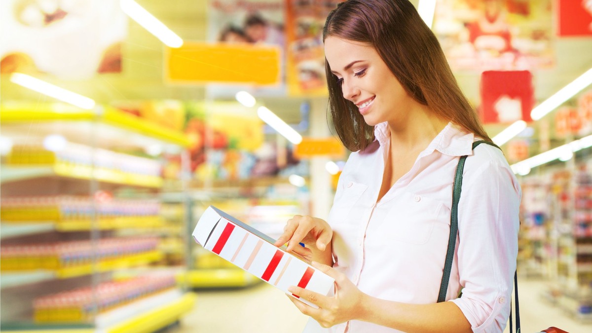 femeie citind eticheta unui produs alimentar