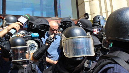 Un barbat este inconjurat de mascați