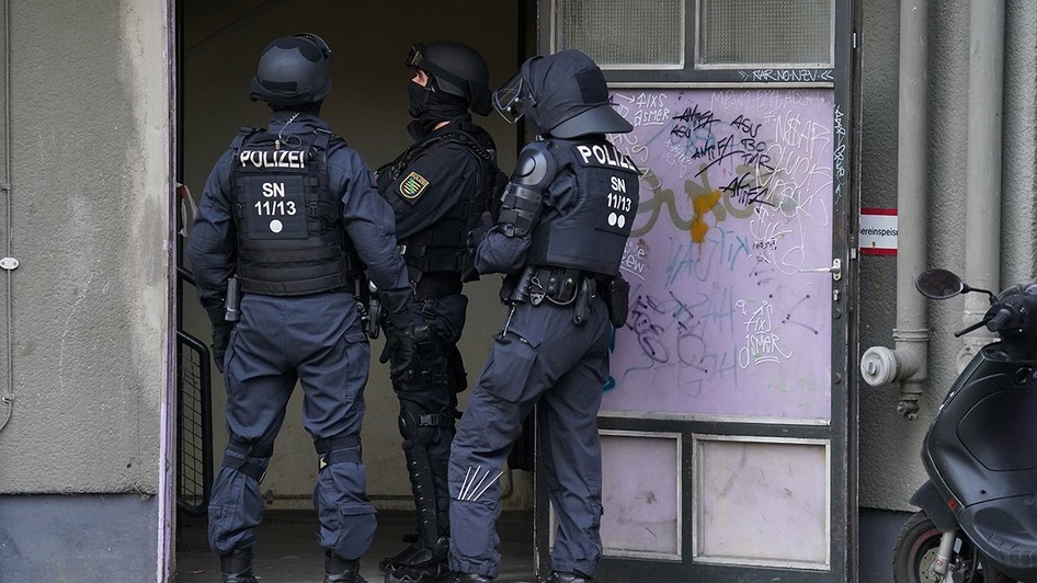 Polițiști înarmați care stau în fața unei clădiri