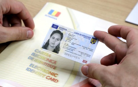 Un bărbat ține în mână o carte electronică de identitate