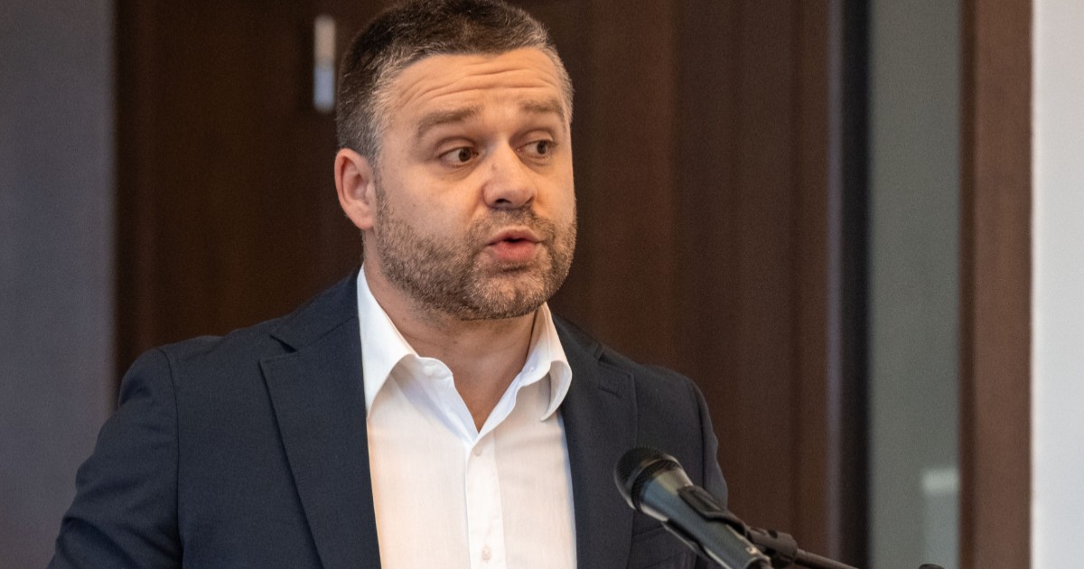 Ciprian Ciucu cu sacou închis la culoare și cămașă albă face declarații în fața unui microfon