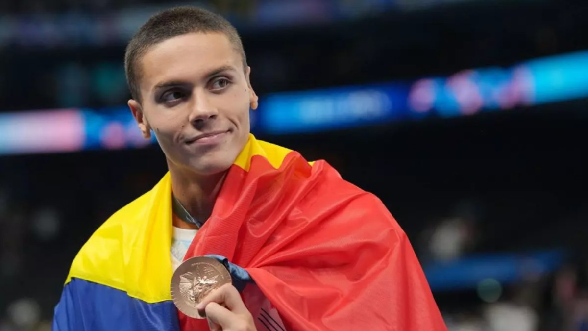 În imagine este ilustrat David Popovici, care poartă tricolorul pe spate