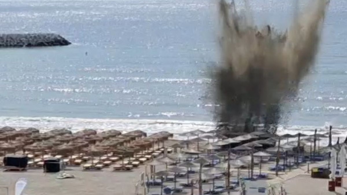 Imagine din depărtare cu un nor de nisip ridicat în aer în momentul în care drona de pe plaja din Olimp este detonată printre șezlonguri