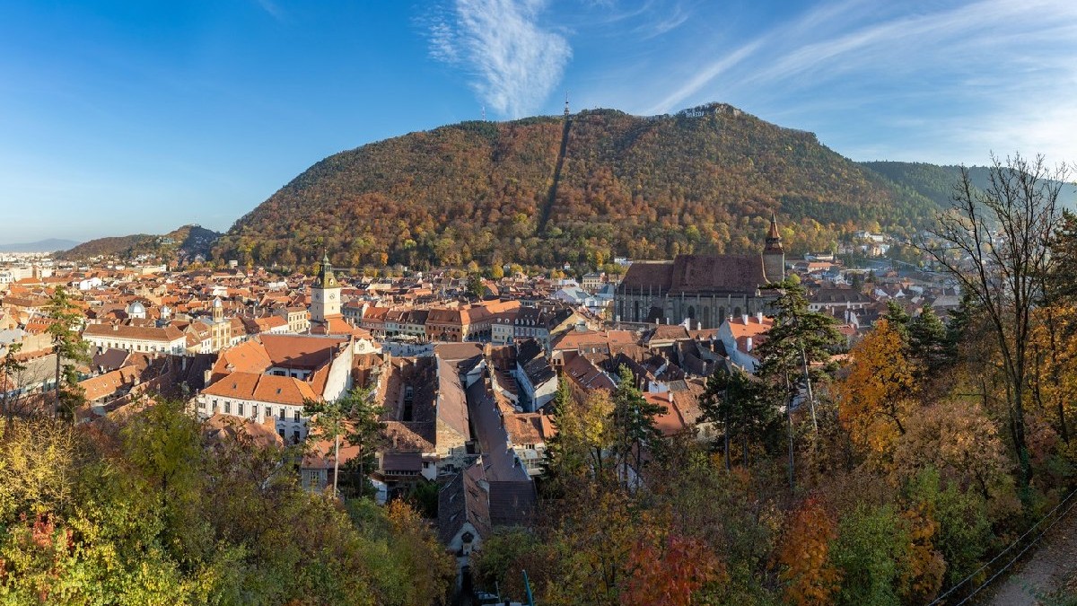 O imagine a orașului Brașov și a peisajului de pe dealul Tampa, toamna.
