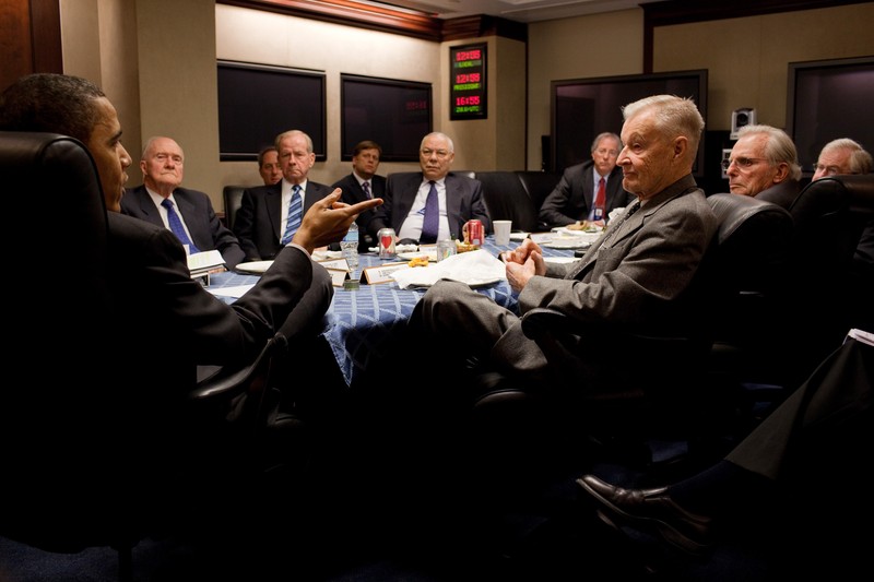 President Barack Obama drops by National Security Advisor Gen. James Jones' meeting with former national security advisors, in the Situation Room of the White House, March 24, 2010. Seated at the table, from left, are Brent Scowcroft, Robert "Bud" McFarlane, Colin Powell, Dennis Ross, senior director for the central region, Sandy Berger, Frank Carlucci, and Zbigniew Brzezinski. (Official White House Photo by Pete Souza) This official White House photograph is being made available only for publication by news organizations and/or for personal use printing by the subject(s) of the photograph. The photograph may not be manipulated in any way and may not be used in commercial or political materials, advertisements, emails, products, promotions that in any way suggests approval or endorsement of the President, the First Family, or the White House.