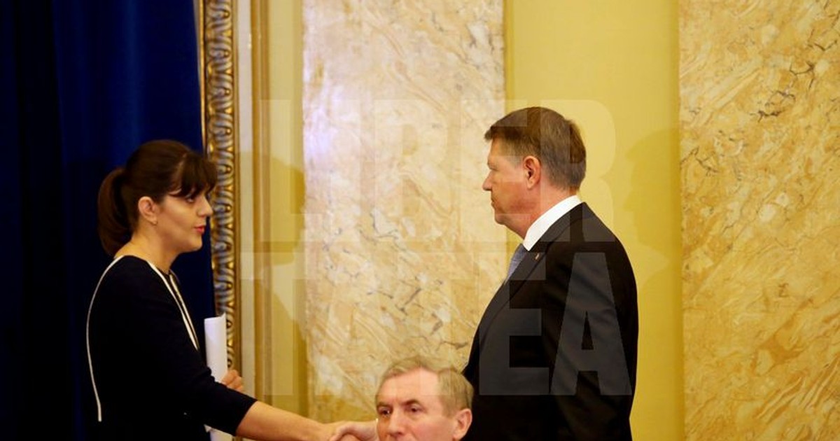 Ce scrie presa internaţională despre revocarea lui Kovesi. Iohannis și Kovesi stau la o masă de prezidiu, la o întâlnire de lucru comună. Klaus Iohannis dă mâna cu Laura Codruța Kovesi, stând în picioare. În fața lor, pe un scaun, stă Augustin Lazăr - Procrurorul General al României