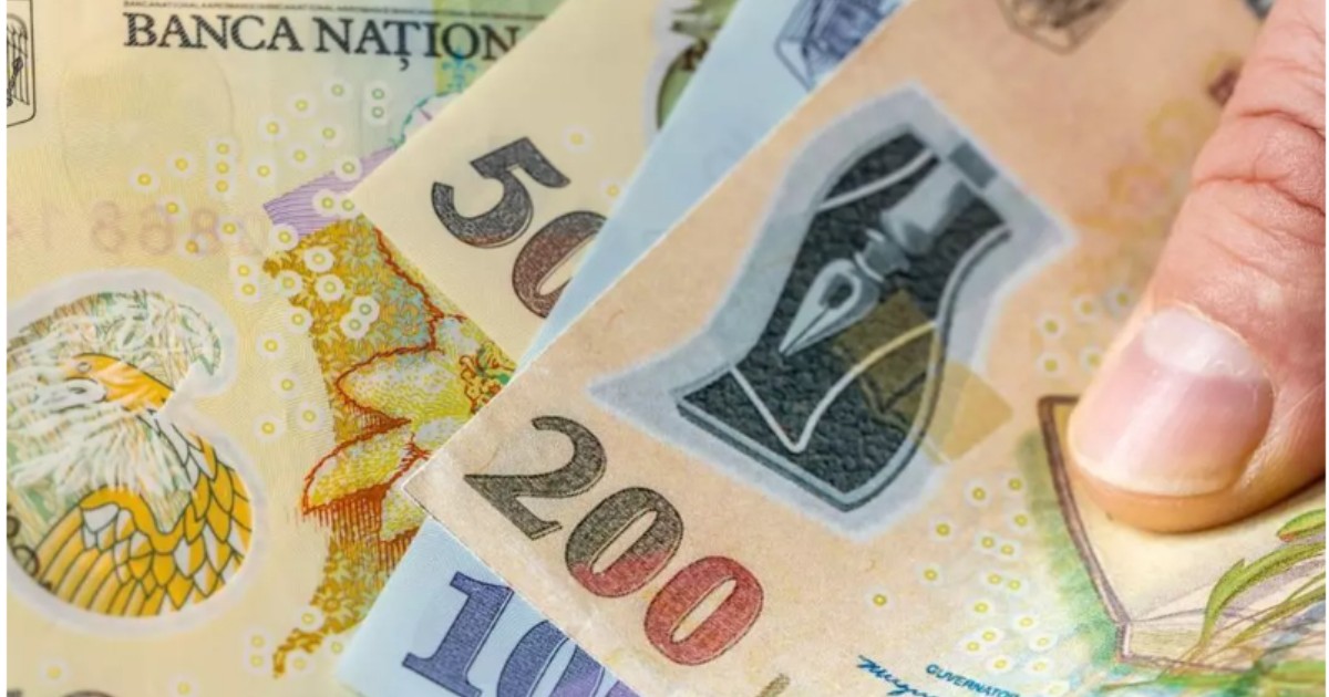 În imagine, un bărbat ține în mână mai multe bancnote