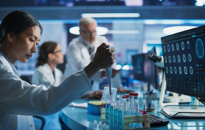 Laboratorul de cercetare în biotehnologie: o doctoriță asiatică care lucrează cu eprubete pentru a studia efectul unui medicament inovator împotriva bolii Alzheimer.