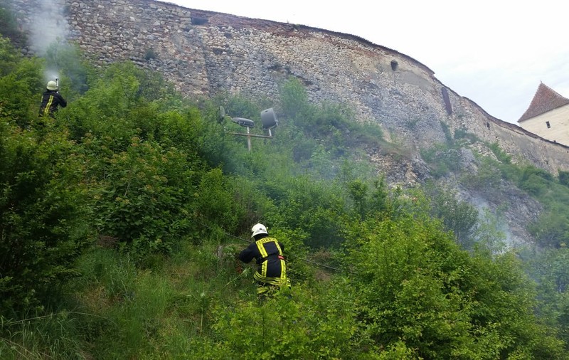 Incendiu de vegetaţie uscată lângă zidurile Cetății Râşnov. Pompierii au stins focul după o oră/ FOTO