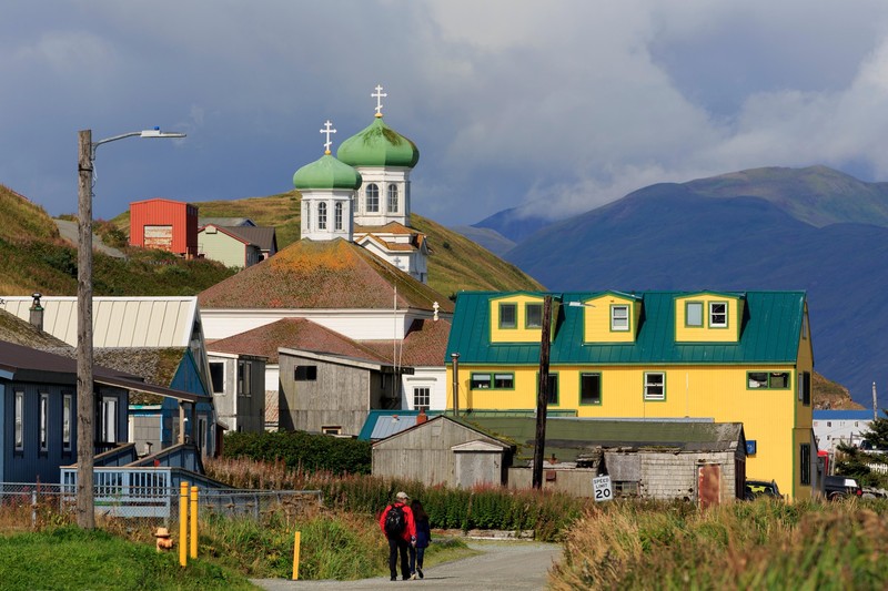 Doi oameni surprinși în timp ce merg pe o stradă din Unalaska, în apropiere de biserica rusă. Foto Profimedia