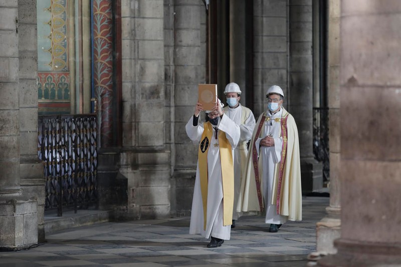 Preoți, cu mască de protecție în timpul unei procesiuni religioase din Săptămâna Mare de la Catedrala Notre Dame | Foto: EPA